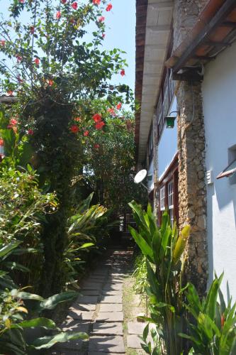 a garden path with flowers on the side of a building at Pousada Arte Colonial - Casarão Histórico do Séc XVIII - Lancha Própria in Paraty