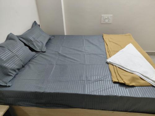 a bed with a blue comforter and pillows on it at sea shore stays in Rushikonda