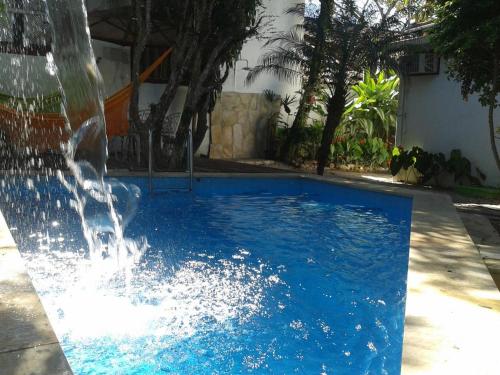 a blue swimming pool with a water fountain at Pousada Arte Colonial - Casarão Histórico do Séc XVIII - Lancha Própria in Paraty