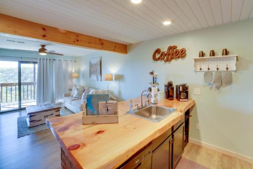 a kitchen with a sink and a living room at Unwind Fireside Ozark Mtn Condo with Resort Perks! in Branson