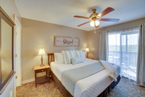 a bedroom with a bed with a ceiling fan and a window at Unwind Fireside Ozark Mtn Condo with Resort Perks! in Branson
