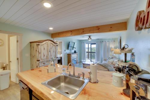 a kitchen with a sink and a living room at Unwind Fireside Ozark Mtn Condo with Resort Perks! in Branson