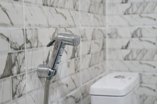 a shower head in a bathroom with a toilet at Gite de la savane in Sindia