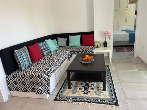 a living room with a couch with colorful pillows at Shaunagh's Place Crag Apartment in Kalymnos