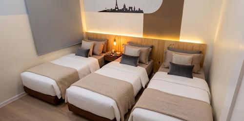a group of three beds in a room at Skudai - The9 Homestay 1min UTM, near Sutera Mall, Paradigm Mall, Senai airport in Skudai
