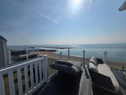 a balcony with a couch and a view of the ocean at Pemberton Avon pitch 30 Creek Caravan Park dog friendly in Ringstead