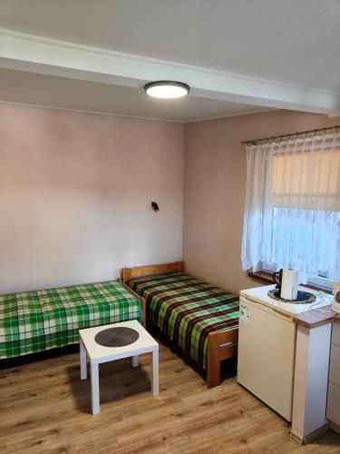 a room with two beds and a table in it at U Władzia in Gowidlino