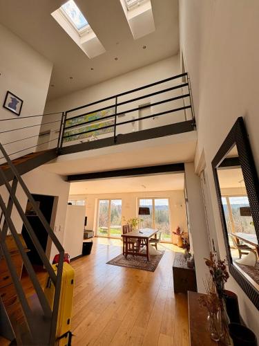 an open living room with a staircase and a table at Weitblick am Mangfalltal in Feldkirchen-Westerham