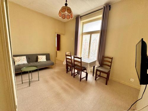 a living room with a couch and a table and chairs at Le Repère de Rumaucourt in Rumaucourt