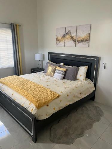 a bedroom with a large bed with gold sheets and pillows at Coral Cove Oasis in Discovery Bay