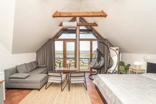 a bedroom with a bed and a couch and a table at Svencelė Resort in Svencelė