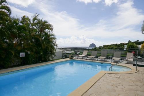 a swimming pool with lounge chairs on top of a building at Villa Diams Diamond in Le Diamant
