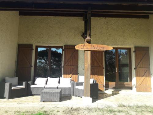 a sign in front of a building with chairs at Le Petiou Landais in Soustons