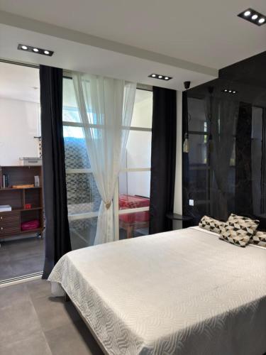 a bedroom with a large bed and a large window at Magnifique vue mer - 2 pièces climatisé avec terrasse à Cap Estérel in Saint-Raphaël