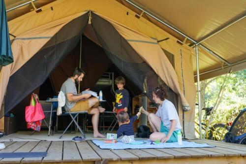 a group of people sitting in a tent at Camping Les Aubazines in Bort-les-Orgues