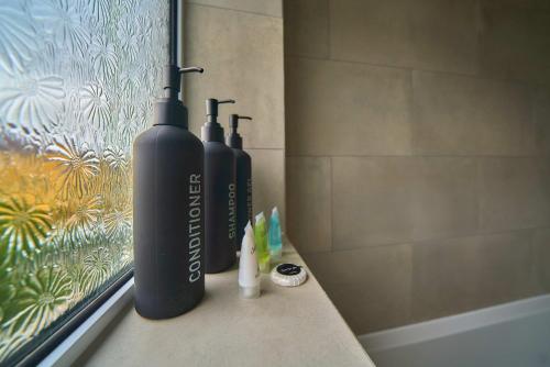two black bottles sitting on a counter in a bathroom at Contractor Base 4BR Fast WiFi Parking High Wycombe in Buckinghamshire