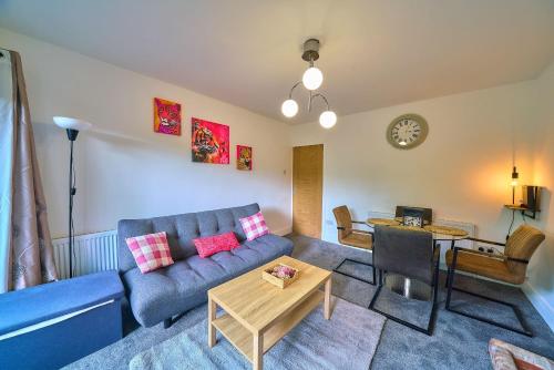 a living room with a blue couch and a table at Spacious 4-Bedroom House in High Wycombe with Parking Fast WiFi in Buckinghamshire