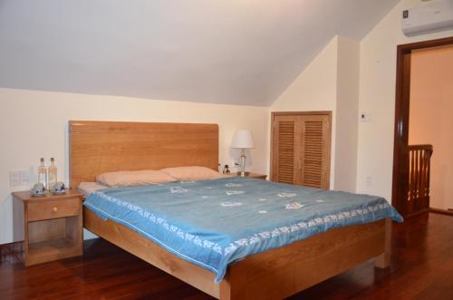 a bedroom with a large bed with a wooden headboard at Kết nối home in Hai Phong