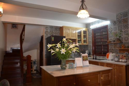 a kitchen with a vase of flowers on a counter at Kết nối home in Hai Phong