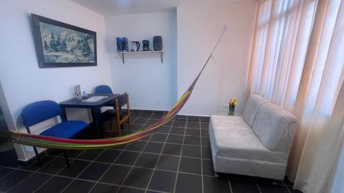 a hammock in a room with a table and a chair at Arauca -Centro in Arauca