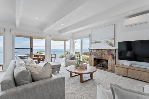 a living room with a fireplace and a television at Clifftop Coastal Sanctuary Panoramic Views in Mount Martha