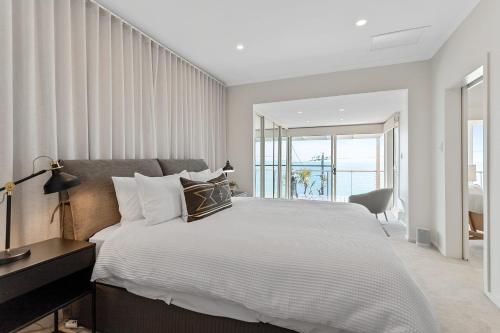 a bedroom with a large bed and a window at Clifftop Coastal Sanctuary Panoramic Views in Mount Martha