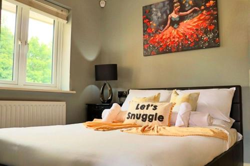 a bedroom with a bed with a painting on the wall at Luxury Heathrow Modern House with Parking & Fast WiFi in Northolt
