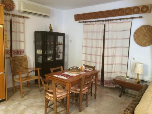 a dining room with a wooden table and chairs at Piskopos Country House in Episkopi Pafou