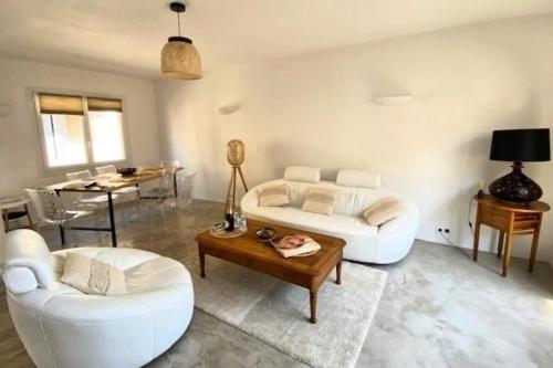 a living room with two white couches and a table at Spacious house with balcony in Sainte-Maxime