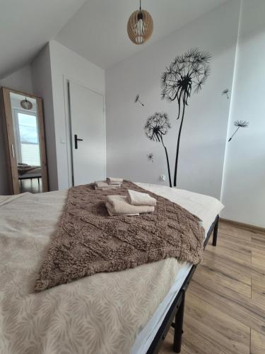 a bedroom with a bed with a blanket and flowers at Domek Noclegowy JoWish in Strachocina