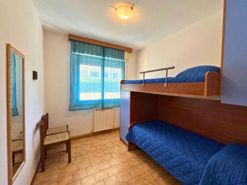 a bedroom with two bunk beds and a window at Condominio Piscina in Grado