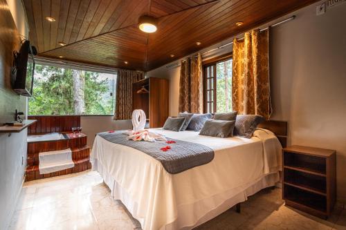 a bedroom with a large bed and a bathroom at Recanto de Moriá in Penedo