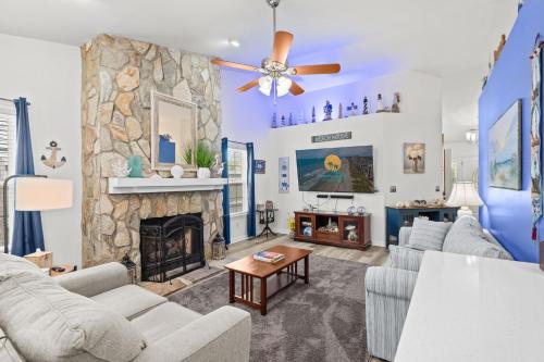 a living room with couches and a stone fireplace at Whispering Marsh Hideaway - Peaceful House in Myrtle Beach