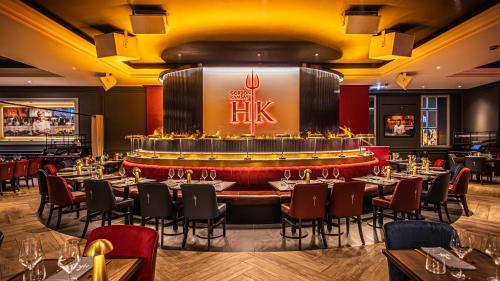 a restaurant with tables and chairs and a bar at The Cumberland, London in London