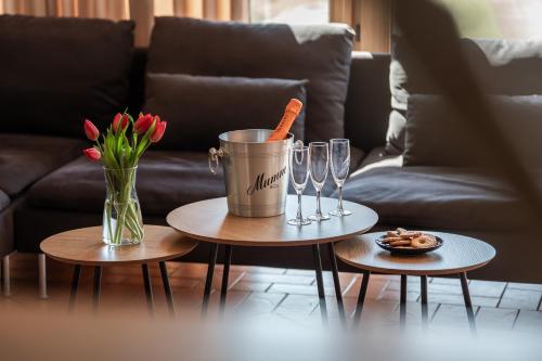a living room with two tables with wine glasses and flowers at Svencelė Resort in Svencelė