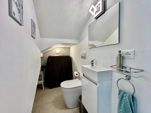 a small bathroom with a toilet and a sink at Villa 124 Residence in Lignano Sabbiadoro