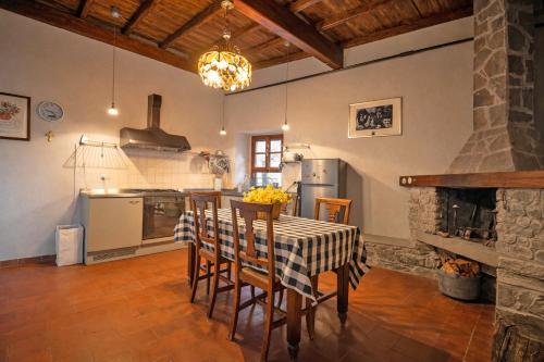 a kitchen with a table and chairs and a fireplace at La Casa del Voltone in Pontremoli