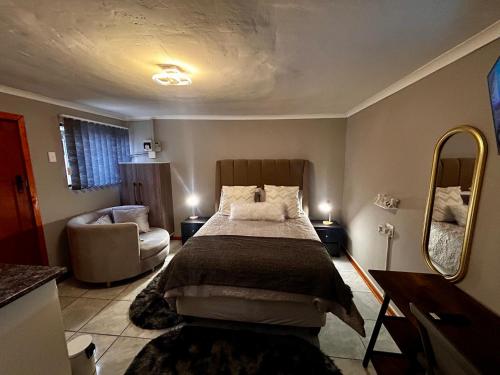 a bedroom with a bed and a chair and a mirror at Awezi Overnight in Coldstream