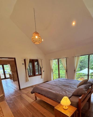 a bedroom with a large bed and large windows at Peach's House in Katiet