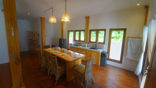 a dining room with a wooden table and chairs at Peach's House in Katiet