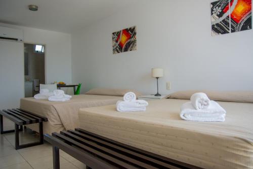 two beds with towels on top of them in a room at Torre Potosi Departamentos in Rosario