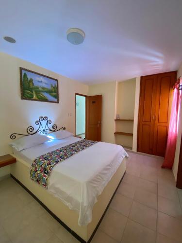 a bedroom with a large white bed in a room at Hotel Terranova SM in Santa Marta