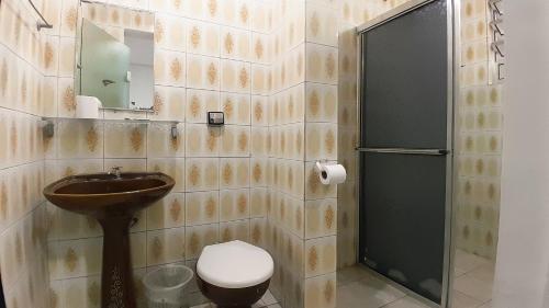 a bathroom with a toilet and a sink and a shower at Center Plaza Hotel in São Paulo