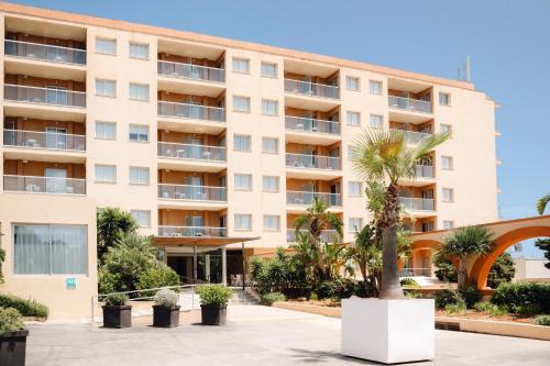 a building with a palm tree in front of it at BLUESEA Salina Ex MD Atlantic in Es Cana