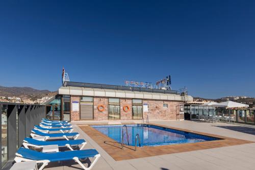 a row of lounge chairs next to a swimming pool at BLUESEA Calabahía in Cala del Moral