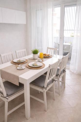 a white dining room table with white chairs and a white table at A Mare in Vasto