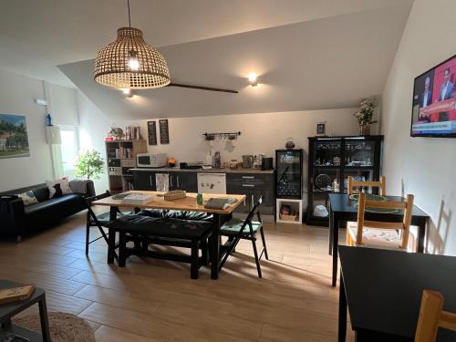 a living room with a table and chairs and a kitchen at Casa do Ti Luís in Leiria