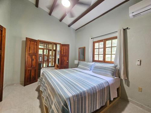 a bedroom with a bed with a blue and white striped blanket at Vacation Home in Pedasí Town
