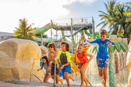a group of children playing on a water park at Sandos Caracol Nature Resort & Water Park All Inclusive in Playa del Carmen