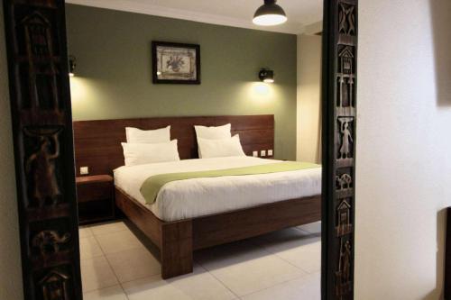 a bedroom with a bed with a green wall at La Colongette in Antsirabe